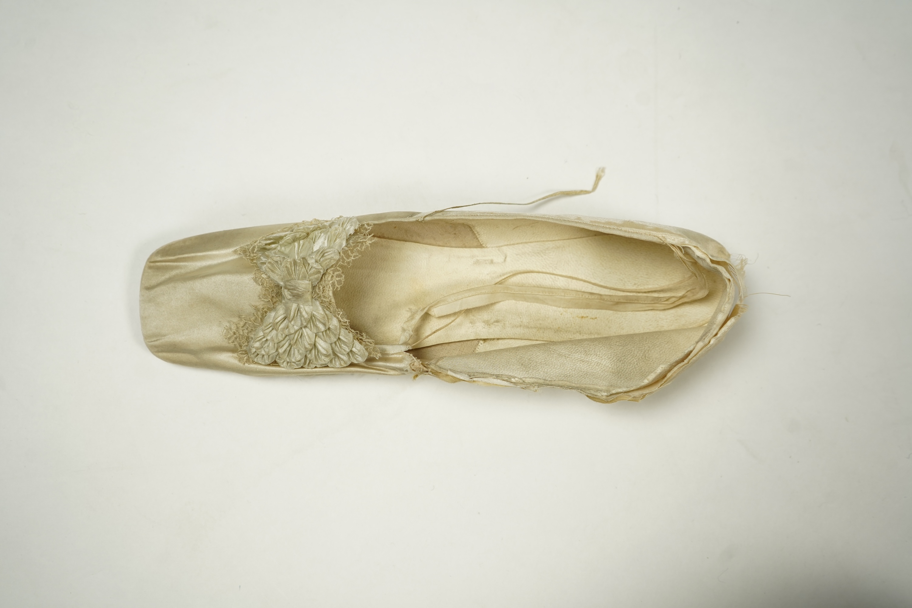 A 19th century hand made cream kid leather ladies ankle boot and four differing cream silk and satin single wedding shoes. All with leather soles. Possibly a traveller's sample range. Boots 24.5cm long (heel to toe). Con
